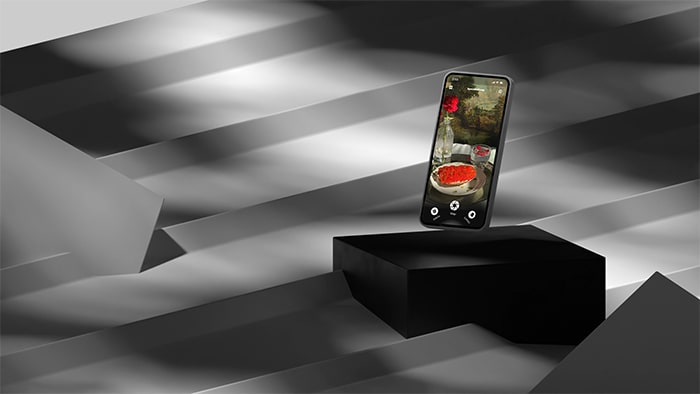 Mobile device floating above black plinth with shadows cast all around