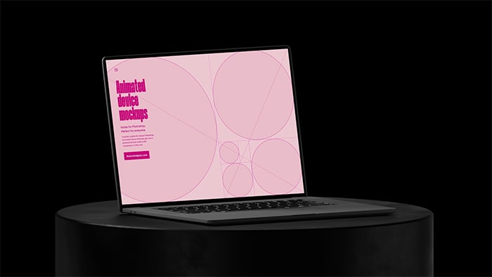 Open laptop sitting on cylindrical black plinth