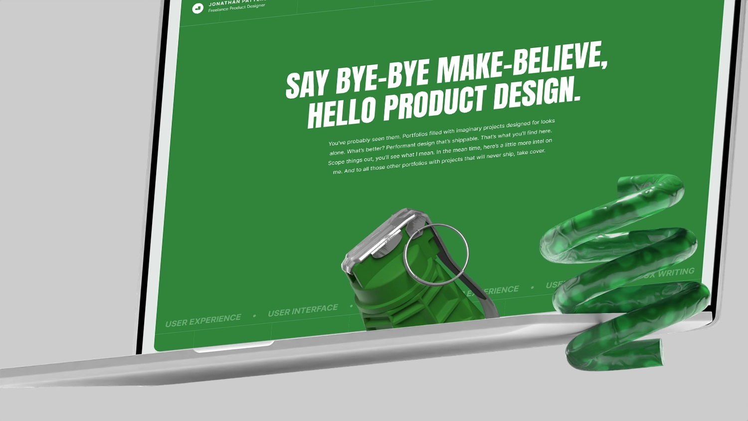 An open laptop on a light background with a decorative green spring object