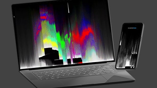 Laptop and mobile device with light streaming from behind on a dark grey background