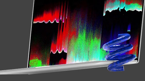 An open laptop on a dark grey background with a decorative green spring object