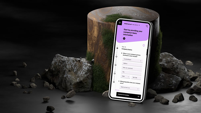 Mobile device leaning against an upright wooden log with rocks all around